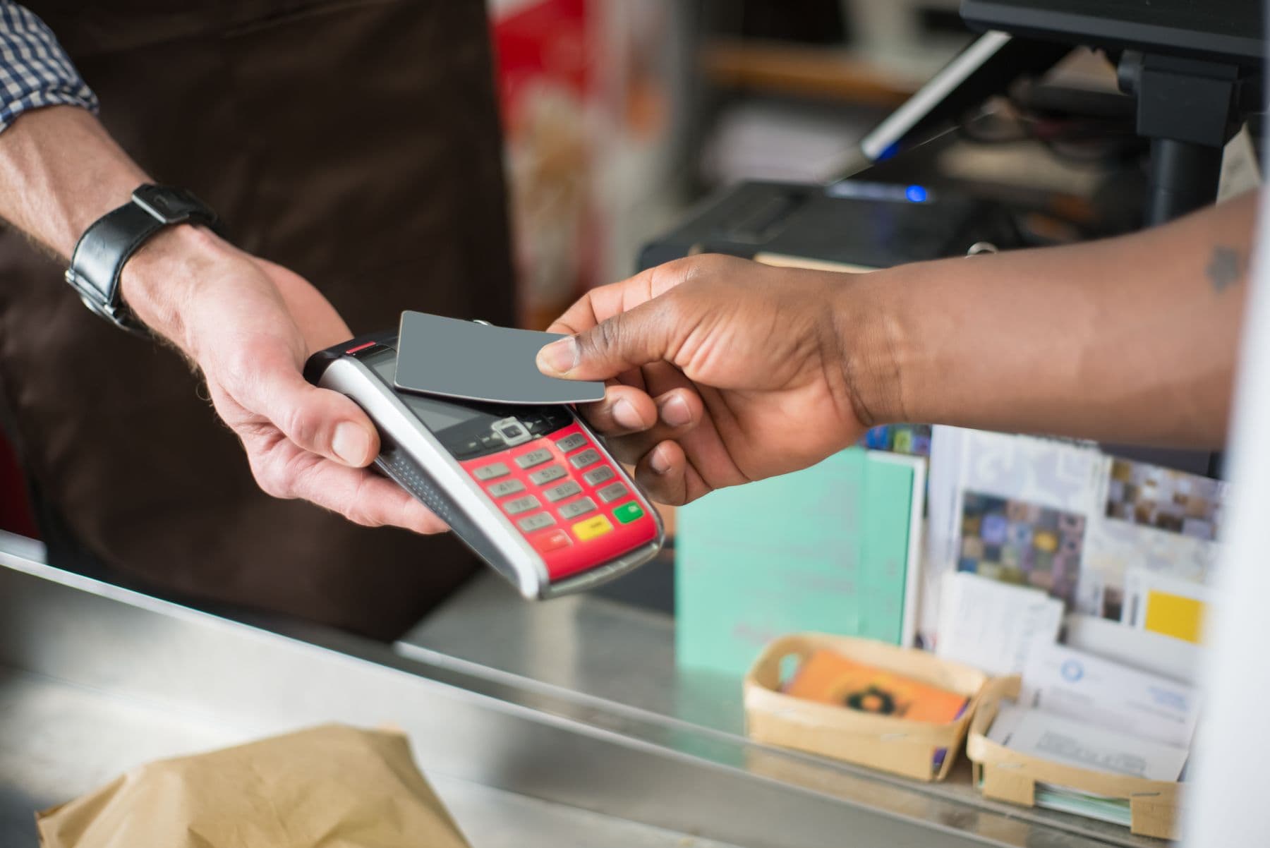 Customer paying with a card terminal at a shop counter