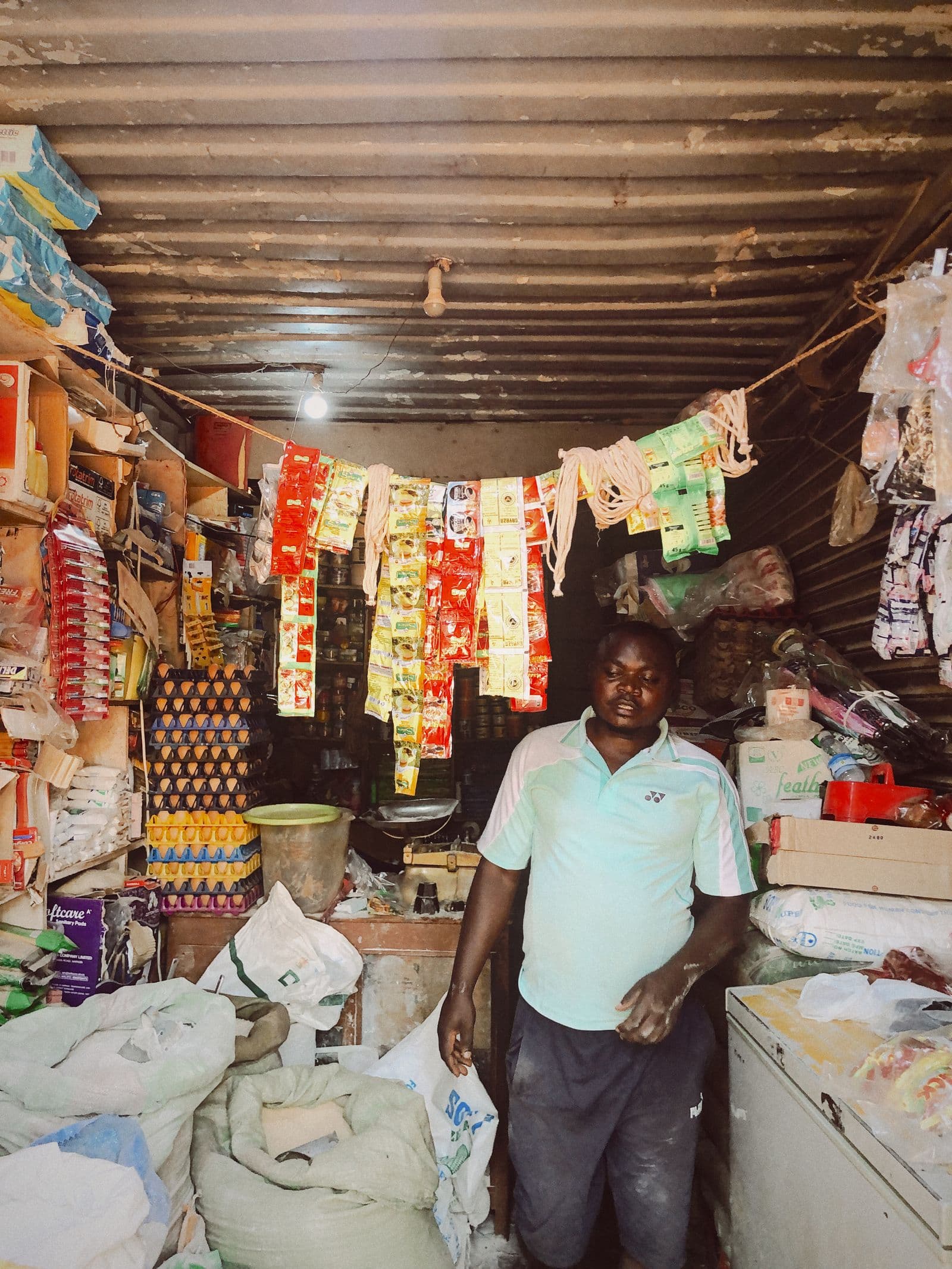 Interior of a small provisions shop with its owner at work