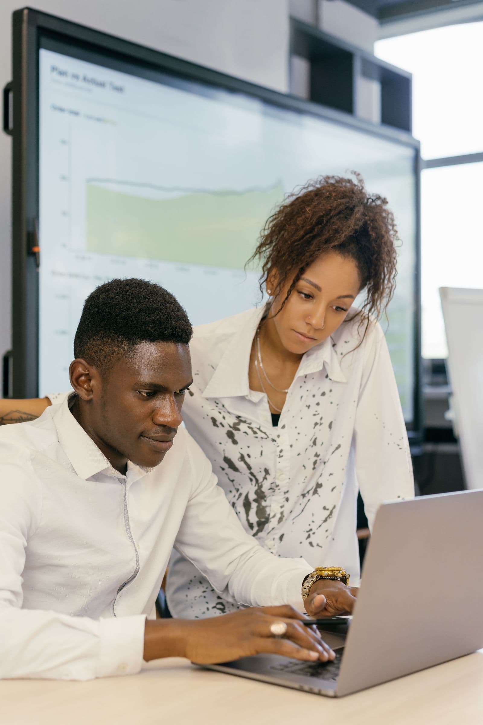 Two startup founders reviewing company numbers on a laptop