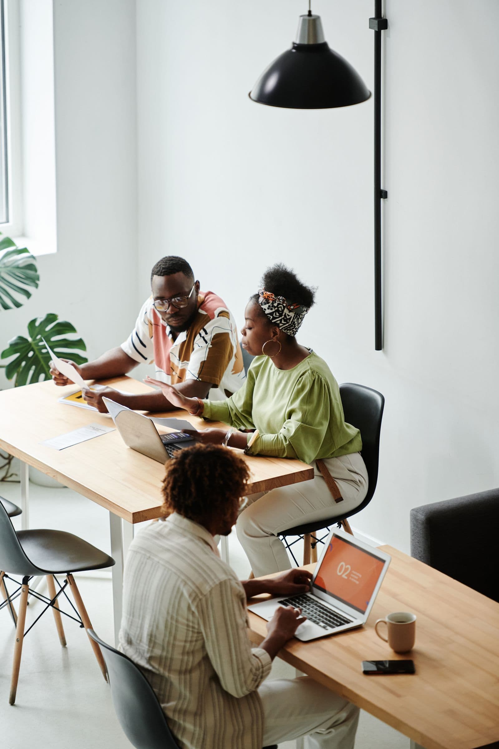 Early-stage startup team working together around laptops in a small office
