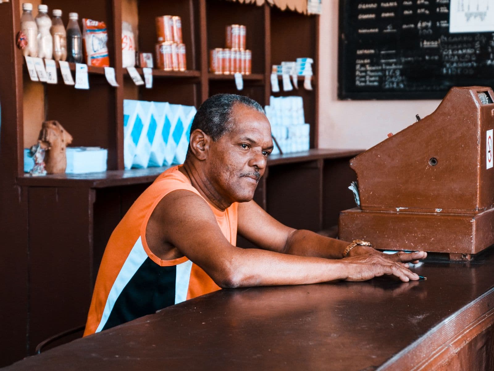 Shopkeeper behind the counter of a neighbourhood store