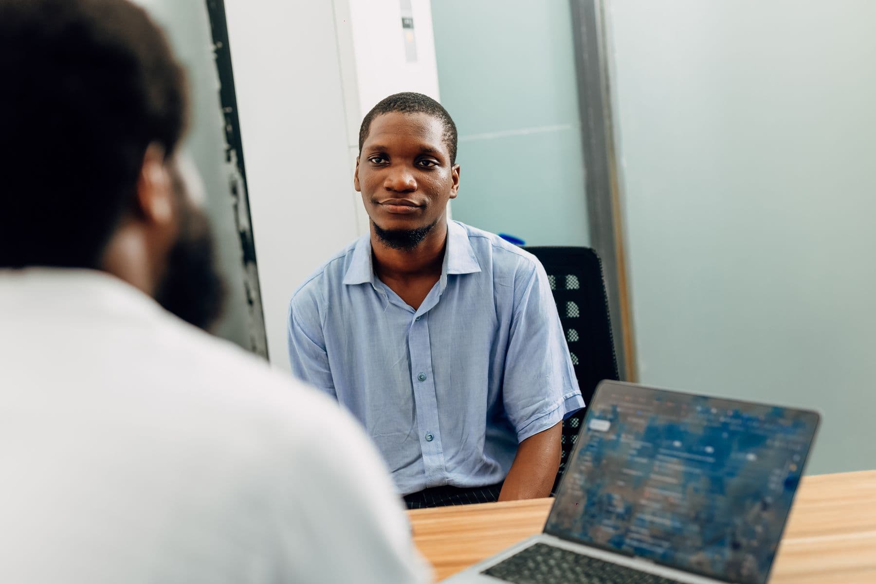 Manager interviewing a candidate across a desk in an office